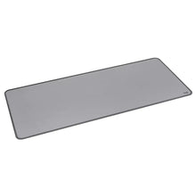 Mid-grey desk mat angled view with rounded corners and stitched border, Logitech logo