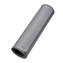 Mid-grey desk mat rolled up with fabric underside and Logitech logo