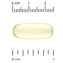 Yellow omega-3 fish oil softgel capsule beside inch/cm measuring scale