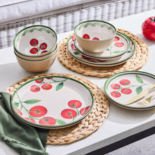 Tomato-pattern dinnerware set on placemats: plates and bowls, beige and white