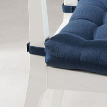 Blue chair seat pad corner straps and tufted cushion edge detail