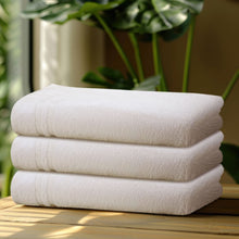 Stack of white bath towels, plush folded layers