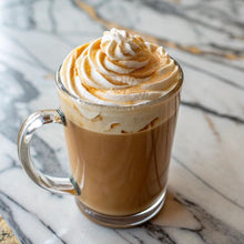 Creamy latte in a glass mug with whipped foam topping