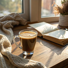 Glass mug of creamy decaf instant coffee with light crema, on wooden table