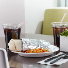 Heavy-duty aluminum foil covering a prepared food tray with utensils nearby