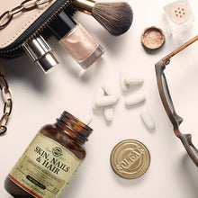 Amber supplement bottle with Solgar Skin, Nails & Hair tablets and capsules around it.