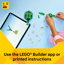 Green turtle building toy pieces and hand assembling on a play mat