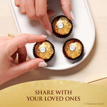 Hands placing Ferrero Rocher chocolates on a white plate