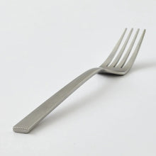 Satin stainless steel fork with ribbed handle and four tines close-up
