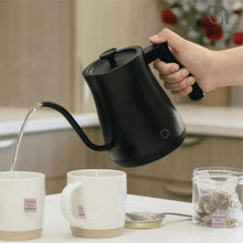 Black electric gooseneck kettle being poured by hand over cups