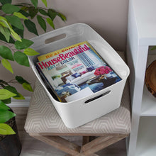 White plastic storage bin with side handles holding magazines on shelf