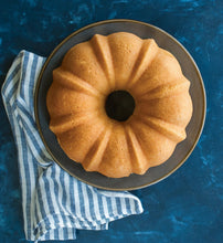 Golden bundt cake in pan with ridged texture and central hole