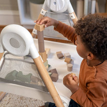 Toddler using white step stool with light-wood legs and small accessory tray