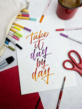 Plum fineliner pen with orange body near scissors and note paper