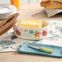 Floral butter dish with acacia wood lid open, butter inside, green serving knife