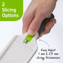 Mini mandoline slicer with green adjustment slider and dark hand guard