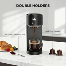 Black drip coffee maker with capsule holders and brewed coffee in mug