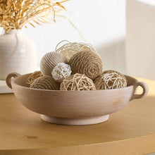 Taupe ceramic bowl with two handles, styled with yarn balls