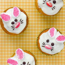 Easter cookies with white icing and pink sprinkle accents in a cat-ear shape