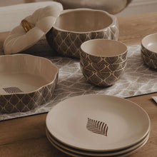 Stoneware cereal bowls with Ocee Leaf pattern, stacked on table with matching serving pieces