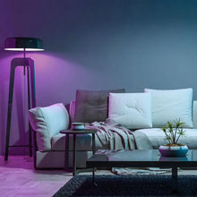 Color-changing smart LED bulb glowing purple in a floor lamp
