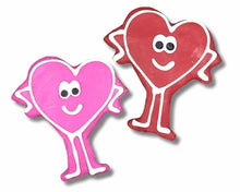 Heart-shaped dog treats with smiling faces in pink and red