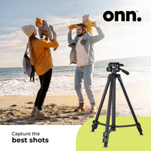 Compact camera tripod with adjustable legs and top phone/camera mount on sand