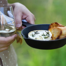 Black cast iron skillet with creamy dish and toast, loop handle