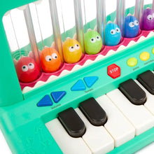 Close-up of green crocodile piano toy keys with colorful character drums