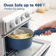 Navy ceramic pot with detachable handle being placed into an oven for cooking.