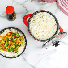Red electric multi-cooker pot with rice inside and glass lid