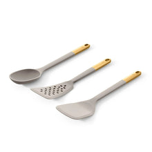 Silicone kitchen utensils set with light gray heads and gold-tone handles: spoon, spatula, slotted turner