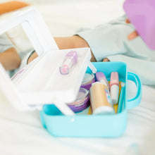 Pretend makeup kit accessories spilling from open blue plastic case