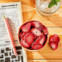 Freeze-dried strawberry fruit crisps in bowl, red sliced strawberries and crisp pieces