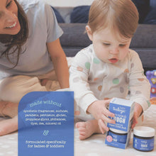 Oilogic vapor chest rub bottle on bedside table with baby and parent
