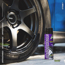 Wet tire finish spray can standing beside black alloy wheel