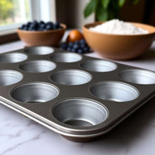 Gray nonstick muffin pan with 12 cup wells and raised rim