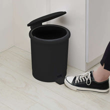 Black plastic step trash can with open lid and foot pedal base