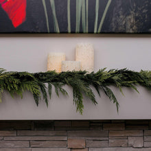 Green evergreen cedar garland across a fireplace mantel with fringe-like branches