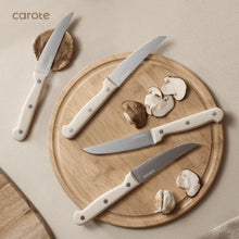 Carote stainless steel knives with white handles laid on a wooden cutting board