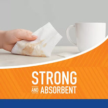 Paper towel sheet being picked up by hand beside a white mug