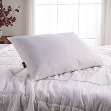 White cooling pillow on a bed with quilted white comforter