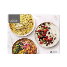 White porcelain dinner bowls with pasta, salad, and fruit toppings