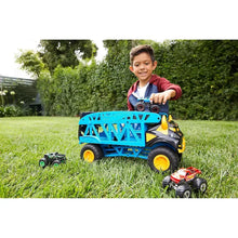 Blue toy monster truck with open bed, yellow wheels, small cars in grass