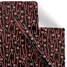 Wrapping paper sheet with black background and repeating red curved candy-cane motifs