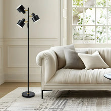 Black 3-head standing floor lamp with round base beside a sofa