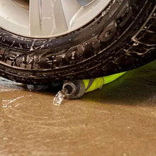 Lime-green hose coupling with water spraying from the metal end fitting