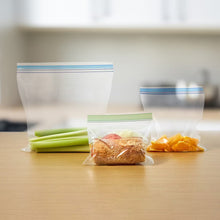Sandwich bags filled with bread and snacks, resealable tops with green strip