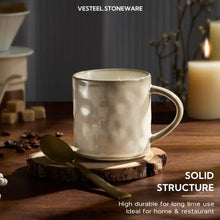Light beige ceramic coffee mug with curved handle and solid textured surface