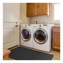 Interlocking dark gray foam floor tile mat with diamond plate texture in laundry room